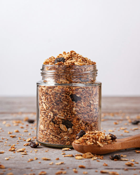 Borcan cu granola și lingură de lemn — gustare sănătoasă pentru birou